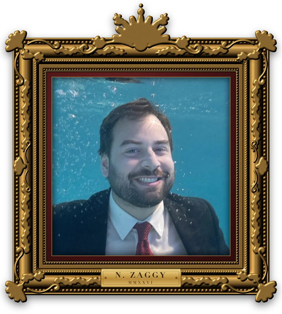 Nick Zaggy smiling underwater in a suit and red tie, inside an ornate gilded frame.