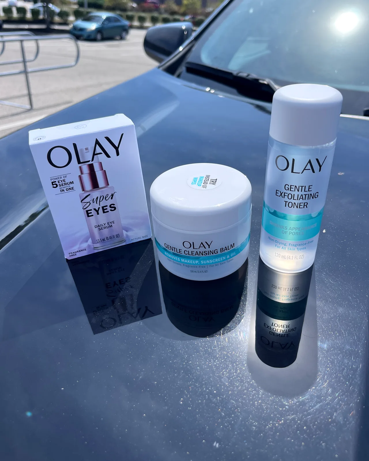 OLAY Super Eyes, Gentle Cleansing Balm and Gentle Exfoliating Toner on a car hood.